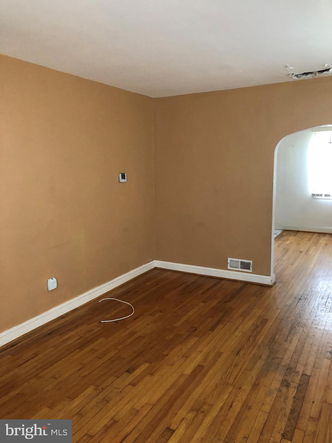 3710 Springwood Avenue Baltimore, MD 21206 - Photo 2 of 12 a view of an empty room with wooden floor and a window