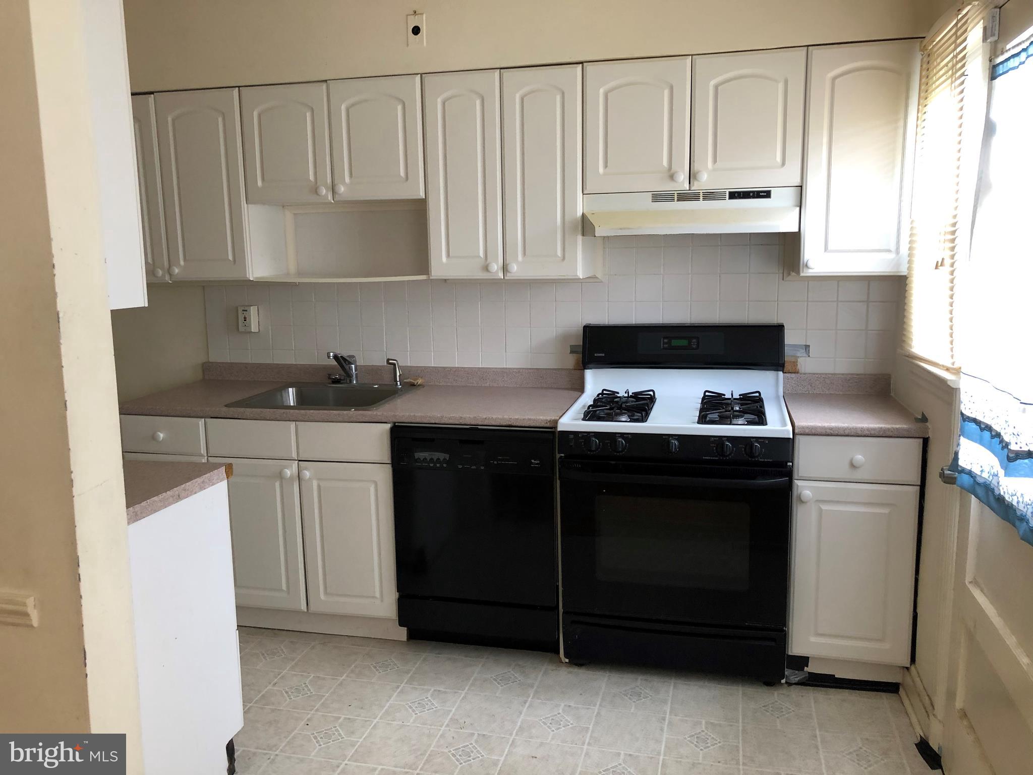 3710 Springwood Avenue Baltimore, MD 21206 - Photo 4 of 12 a kitchen with granite countertop white cabinets and black appliances