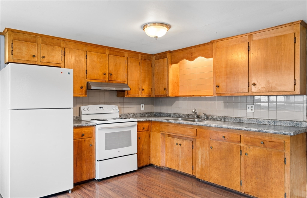 24 Horton Road Orange, MA 01364 - Photo 4 of 32 a kitchen with stainless steel appliances granite countertop a refrigerator a sink dishwasher and wooden cabinets with wooden floor