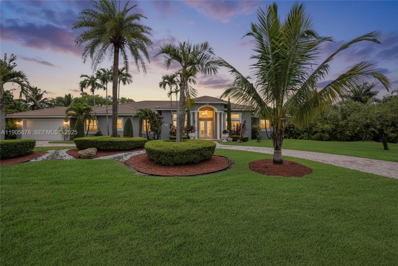 a front view of a house with garden and trees