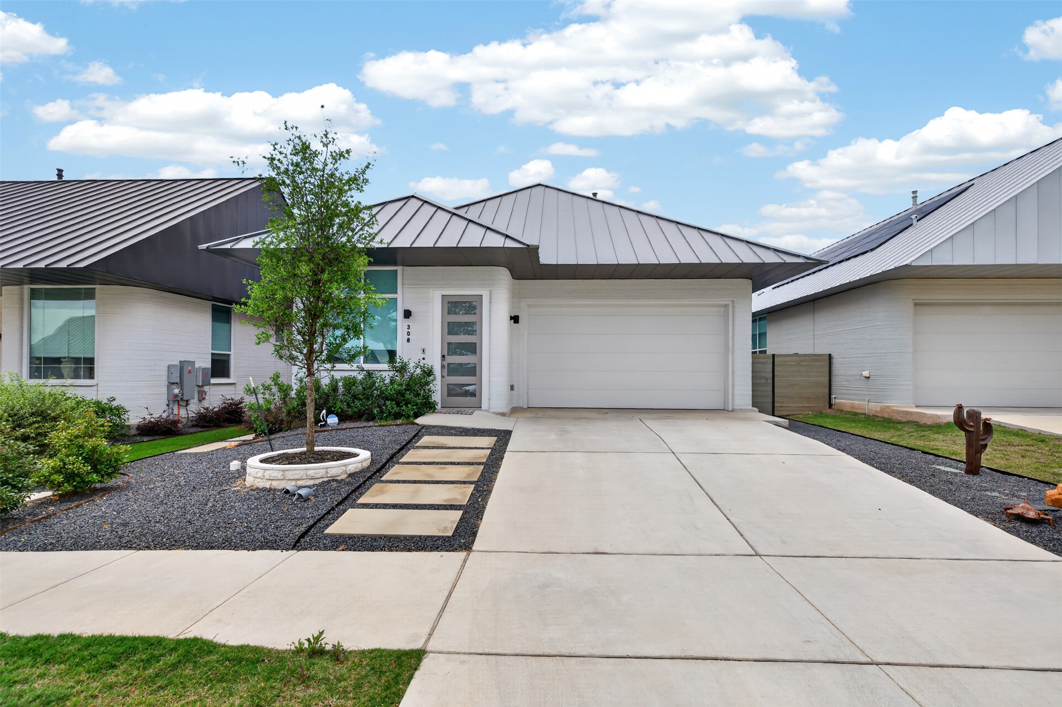 308 Painted Sunset Drive Georgetown, TX 78628 - Photo 1 of 26 Modern white brick exterior with a gray metal roof