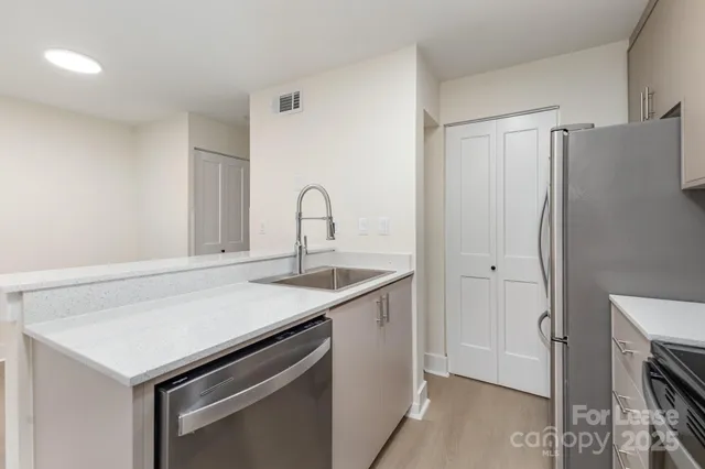 a kitchen with a sink a counter cabinets and appliances