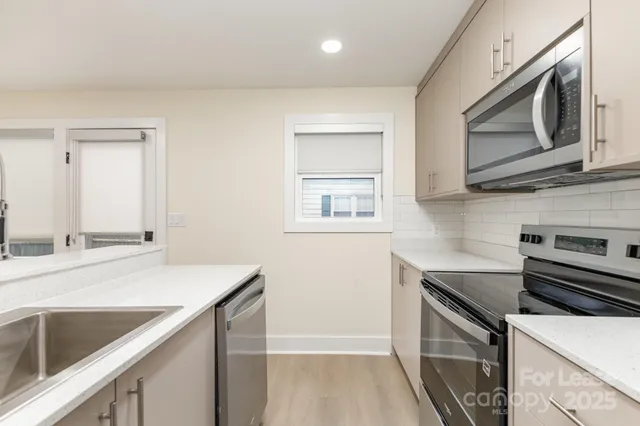 a kitchen with stainless steel appliances granite countertop a sink stove and microwave
