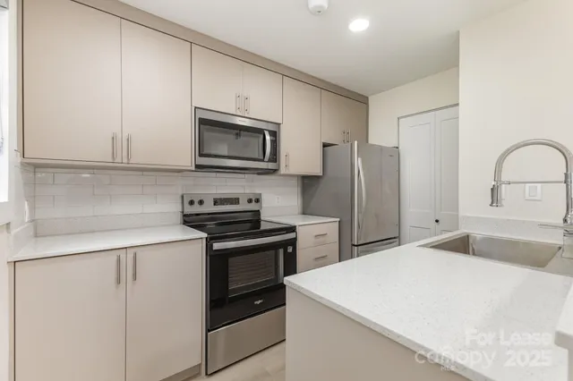 a kitchen with granite countertop a refrigerator stove and microwave