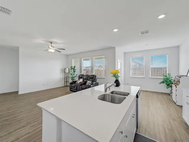 a kitchen with a sink a counter space and wooden floor