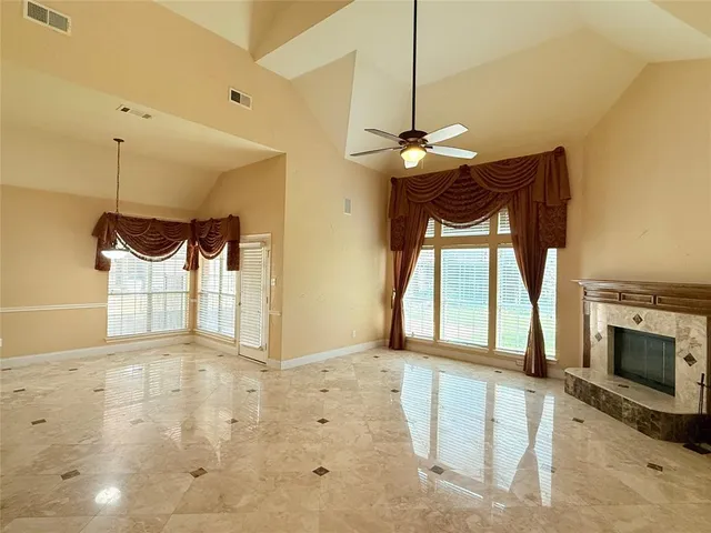 a view of an empty room with a fireplace and a window