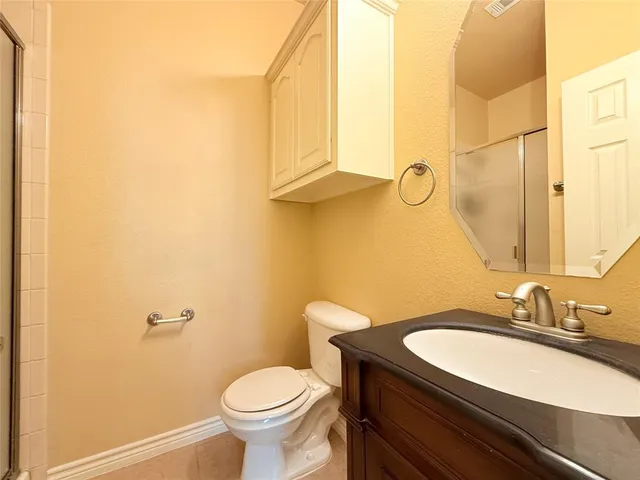 a bathroom with a granite countertop sink toilet and a mirror