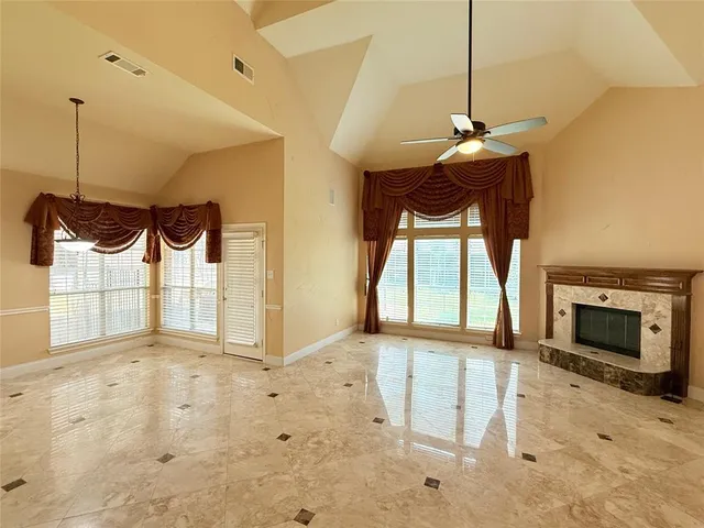 a view of an empty room with a fireplace and a window