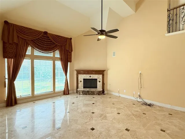 a view of an empty room with a fireplace and a window