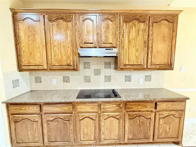 a kitchen with granite countertop a sink and cabinets
