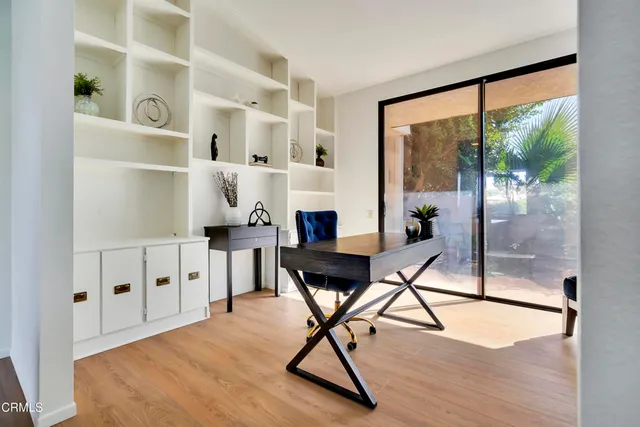 a view of a workspace with furniture and a window