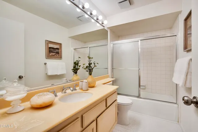 a bathroom with a granite countertop sink a toilet and shower