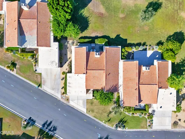 an aerial view of multiple houses with a yard