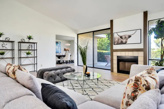 a living room with furniture fireplace and a large window