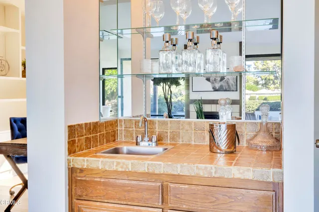 a bathroom with a granite countertop sink and a large mirror