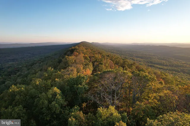 an aerial view of house with yard and mountain view in back