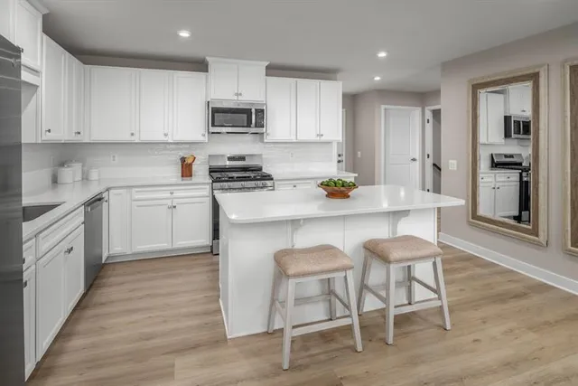 a kitchen with a sink white cabinets and stainless steel appliances