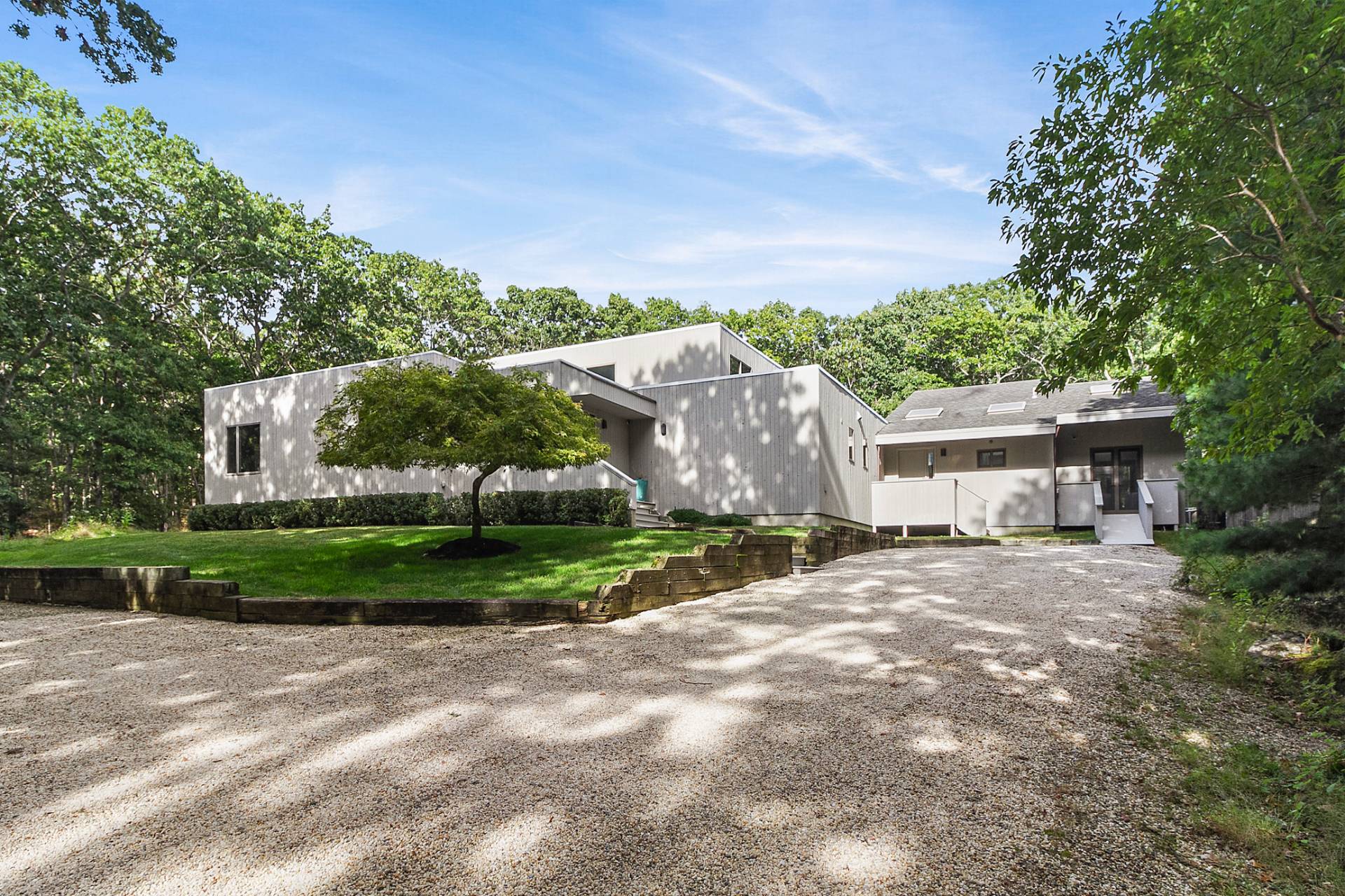 a view of a house with a yard and large trees