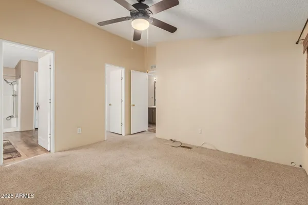 en empty room with ceiling fan and window