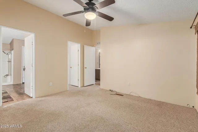 en empty room with ceiling fan and window