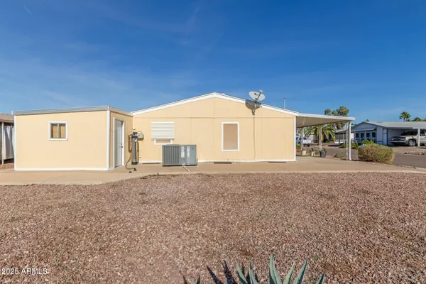 a view of a house with backyard and a tree