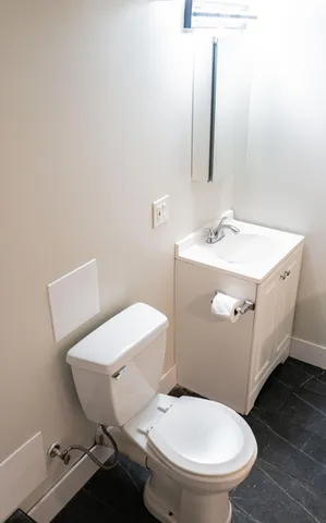 a bathroom with a toilet a sink and mirror