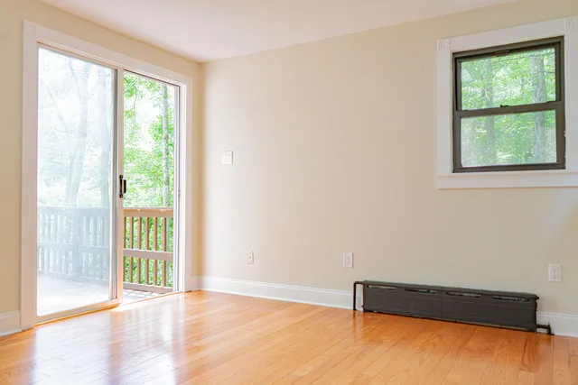 a view of a room with wooden floor and a window