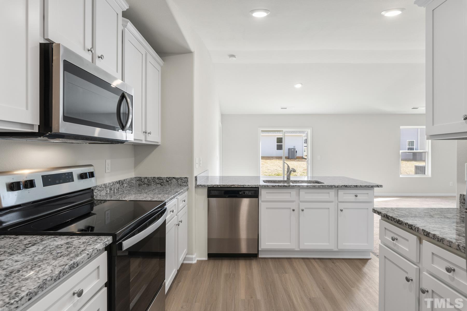 470 Crow Field Street Roxboro, NC 27574 - Photo 11 of 17 a kitchen with stainless steel appliances granite countertop a stove top oven a sink dishwasher and microwave oven with wooden floor