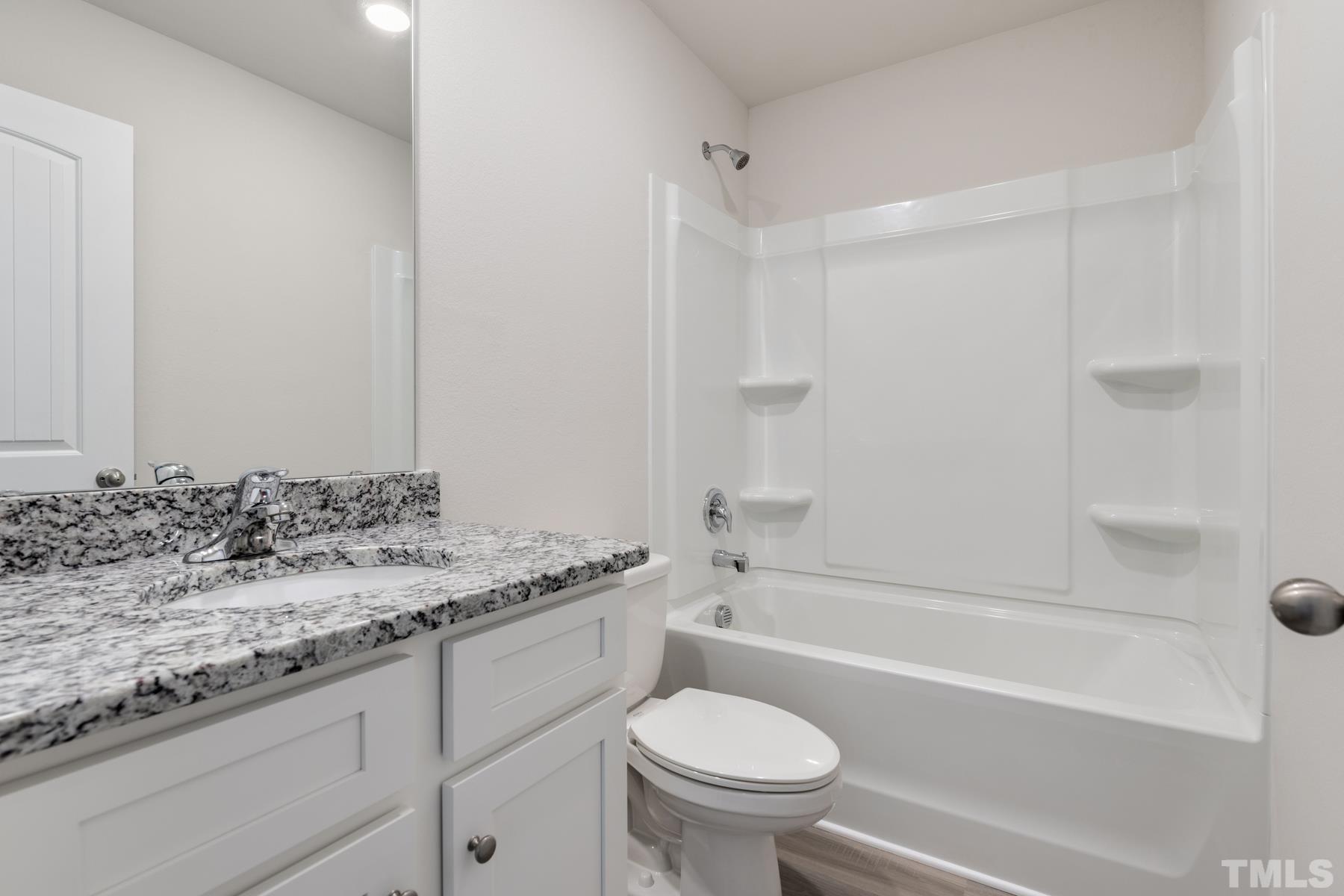 470 Crow Field Street Roxboro, NC 27574 - Photo 17 of 17 a bathroom with a granite countertop sink a toilet and bathtub