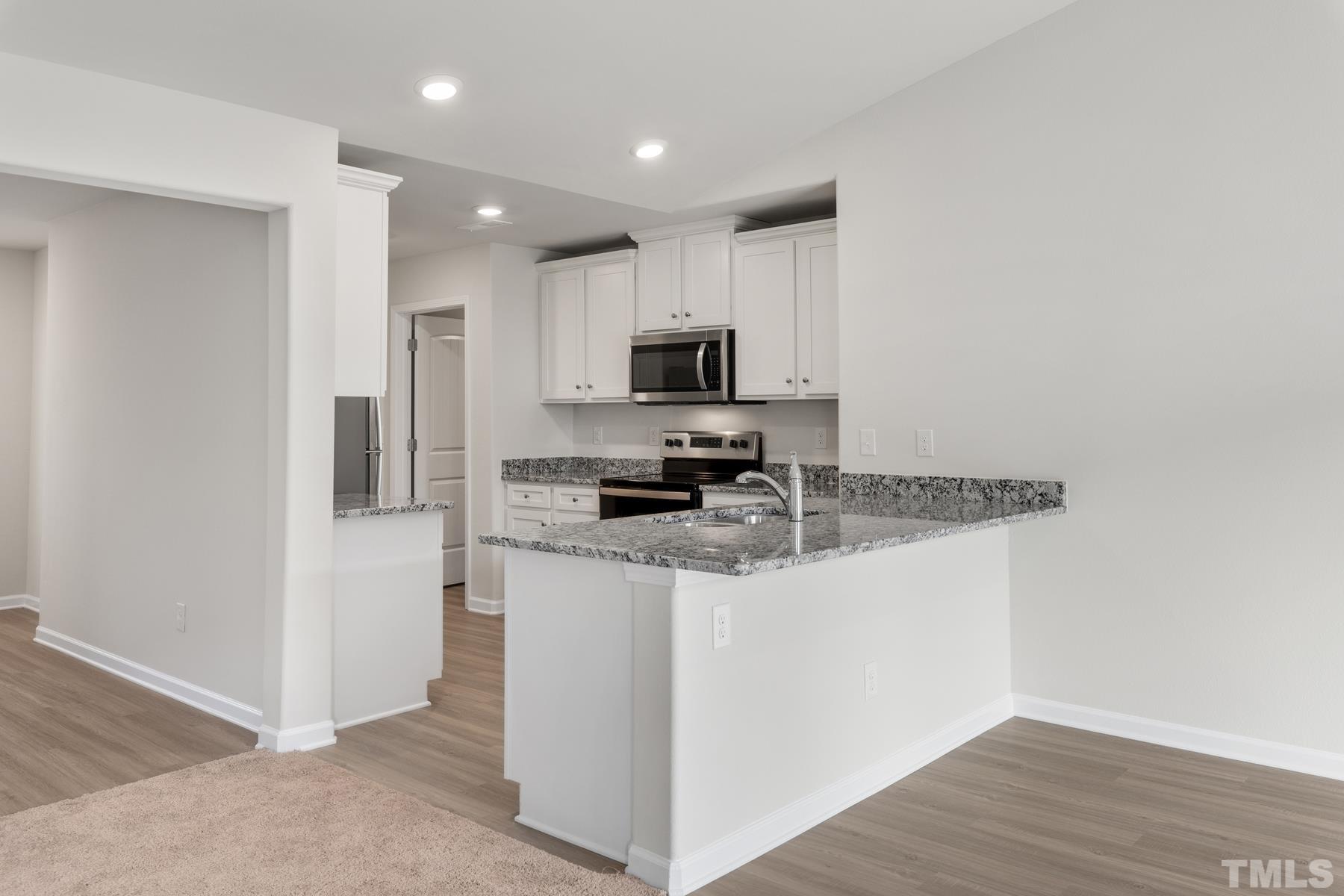 470 Crow Field Street Roxboro, NC 27574 - Photo 6 of 17 a kitchen with stainless steel appliances granite countertop a stove top oven a sink a refrigerator and a granite counter tops