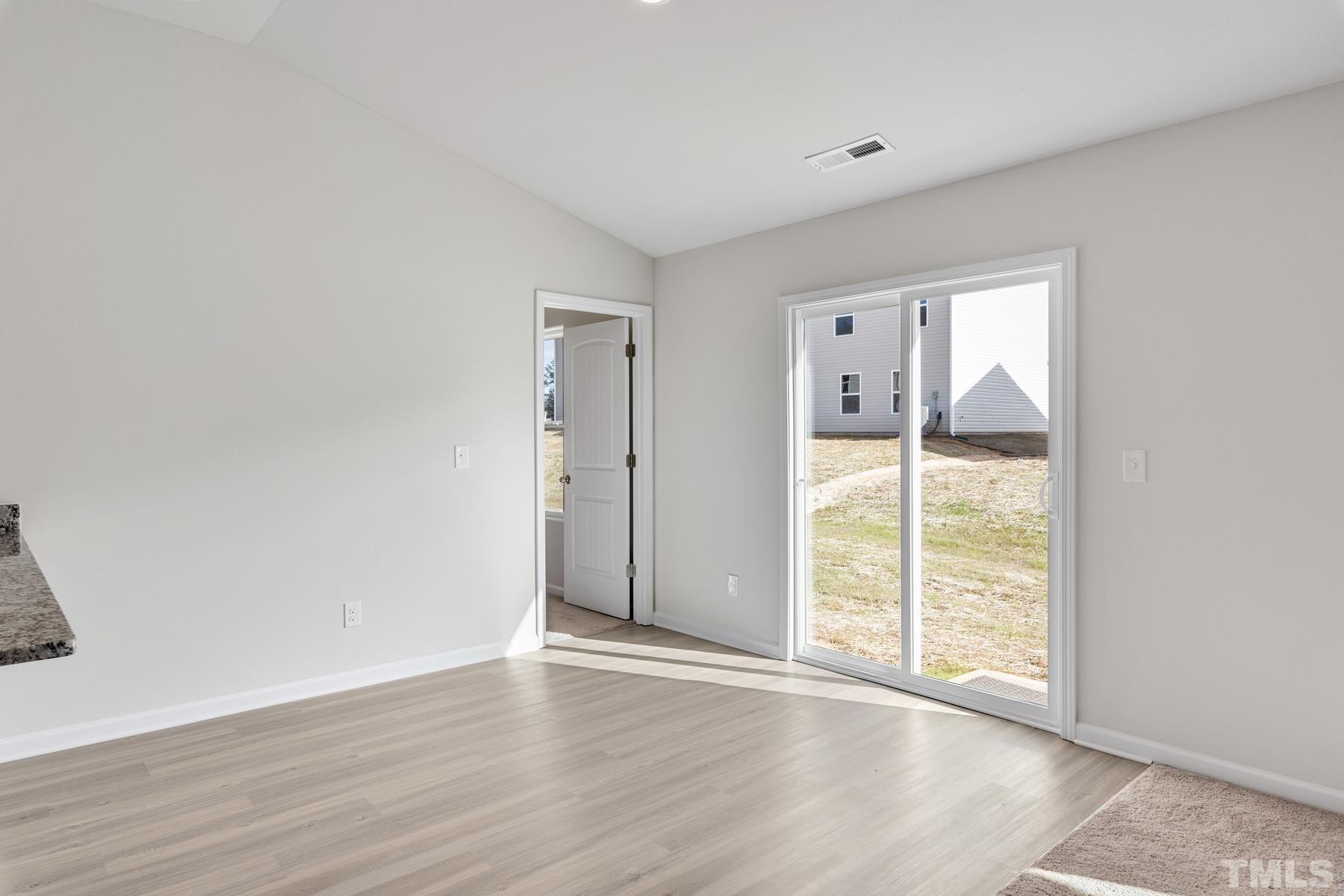 470 Crow Field Street Roxboro, NC 27574 - Photo 7 of 17 an empty room with wooden floor and windows
