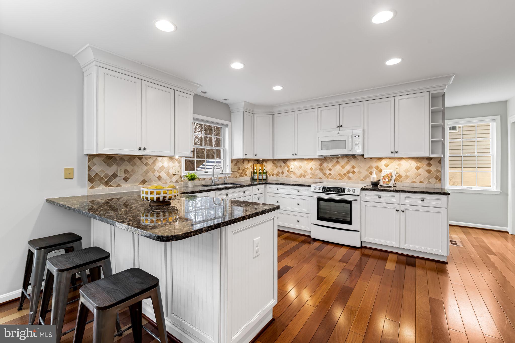 6008 Winter Grain Path Clarksville, MD 21029 - Photo 11 of 53 a kitchen with granite countertop wooden floors and white stainless steel appliances