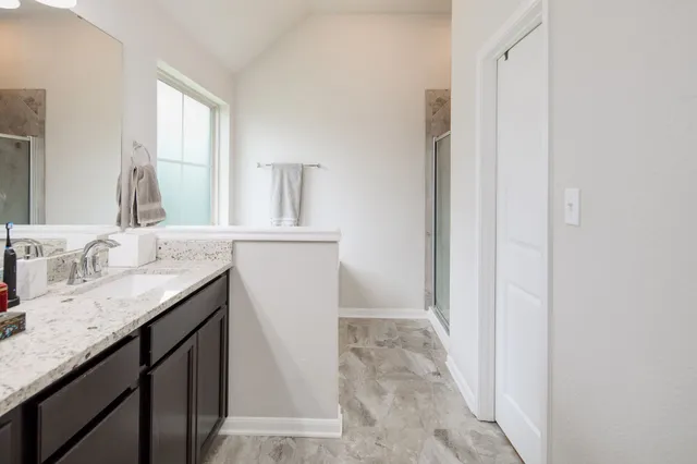 a bathroom with a granite countertop sink and a mirror