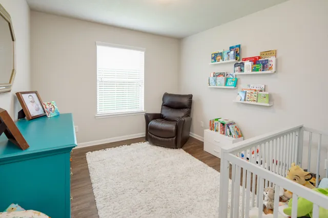 a bedroom with furniture and a wooden floor
