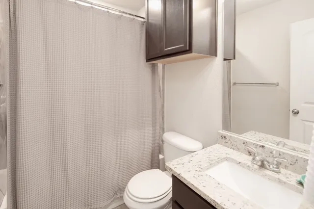 a white toilet sitting next to a bathroom sink