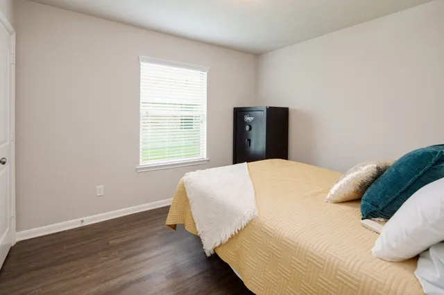a bed sitting in a bedroom next to a window