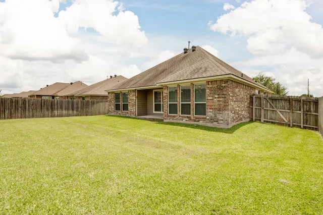 a view of a house with a large pool and wooden fence
