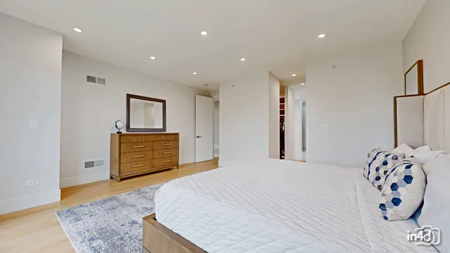 a bedroom with a large bed and a chandelier