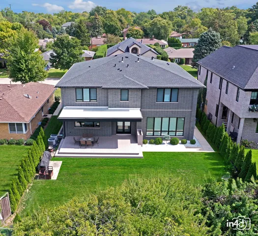 an aerial view of a house with a garden and lake view