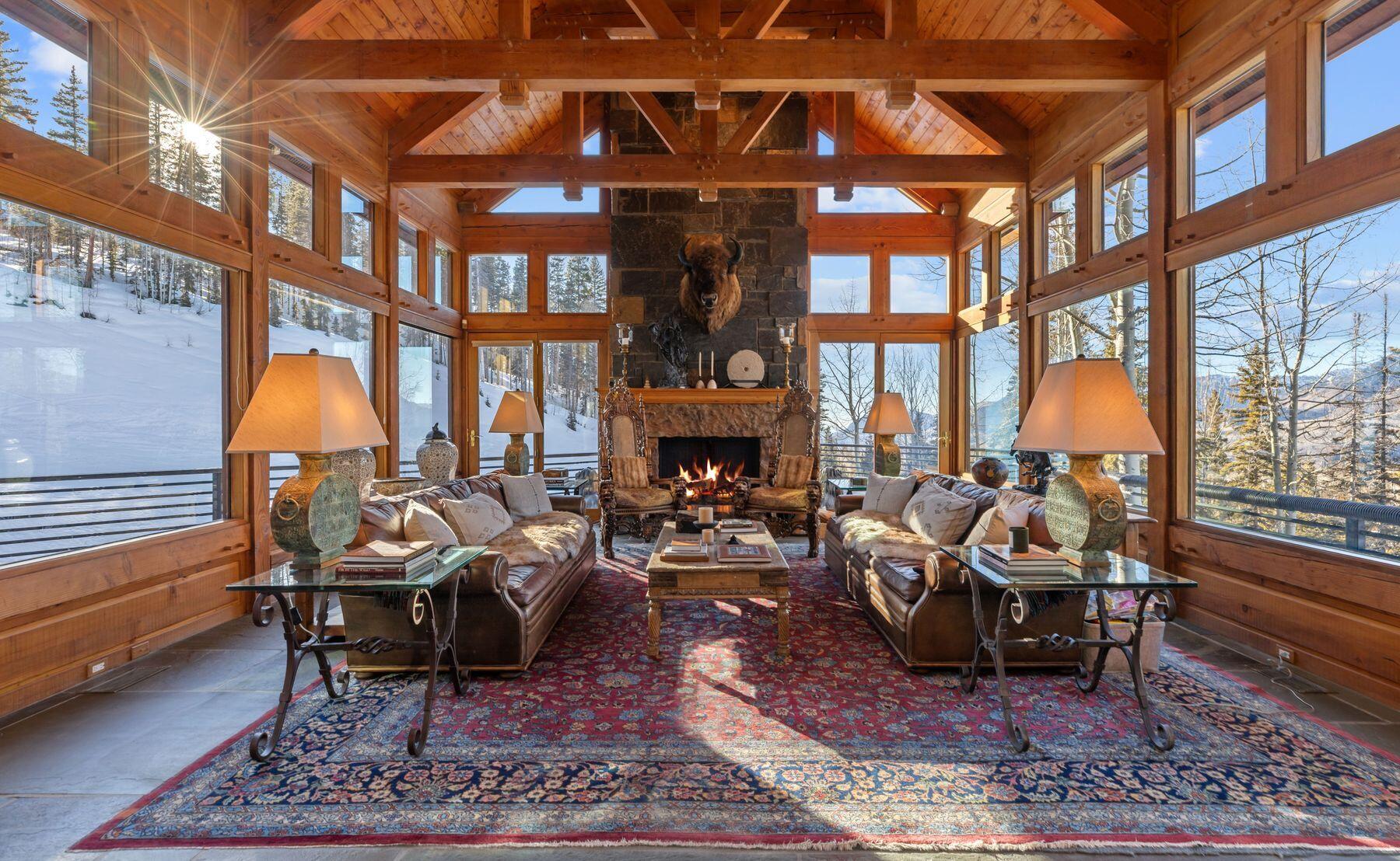 222 High Country Road Mountain Village, CO 81435 - Photo 4 of 37 a living room with furniture a fireplace and large windows