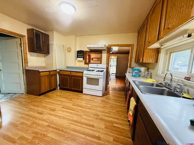 a kitchen with stainless steel appliances granite countertop a sink and wooden cabinets