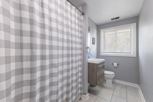 a bathroom with a toilet and a shower curtain