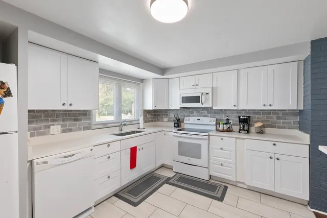a kitchen with white cabinets appliances and sink