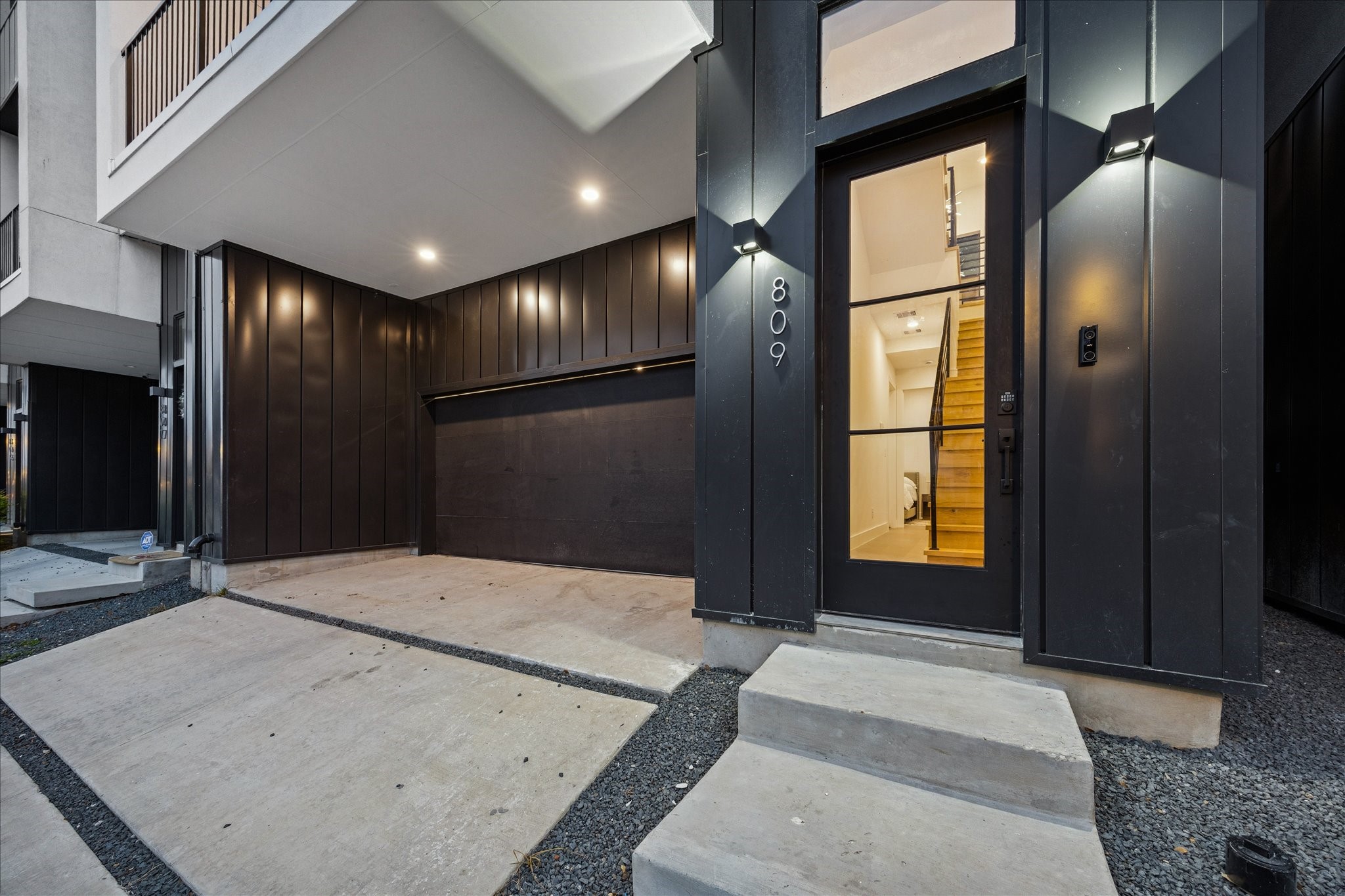 809 Memorial Heights Drive Houston, TX 77007 - Photo 8 of 32 Contemporary exterior with a private driveway, oversized two-car garage, and a striking glass-front entry showcasing sleek architectural lines.