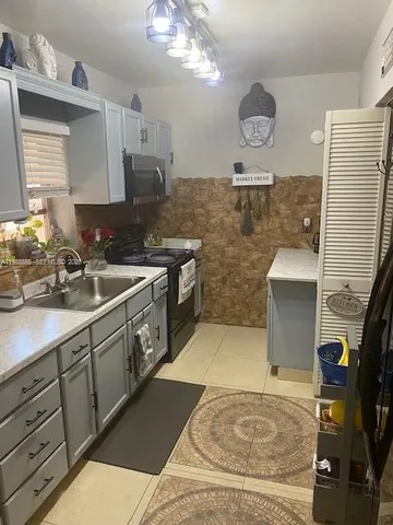 a kitchen with cabinets and wooden floor