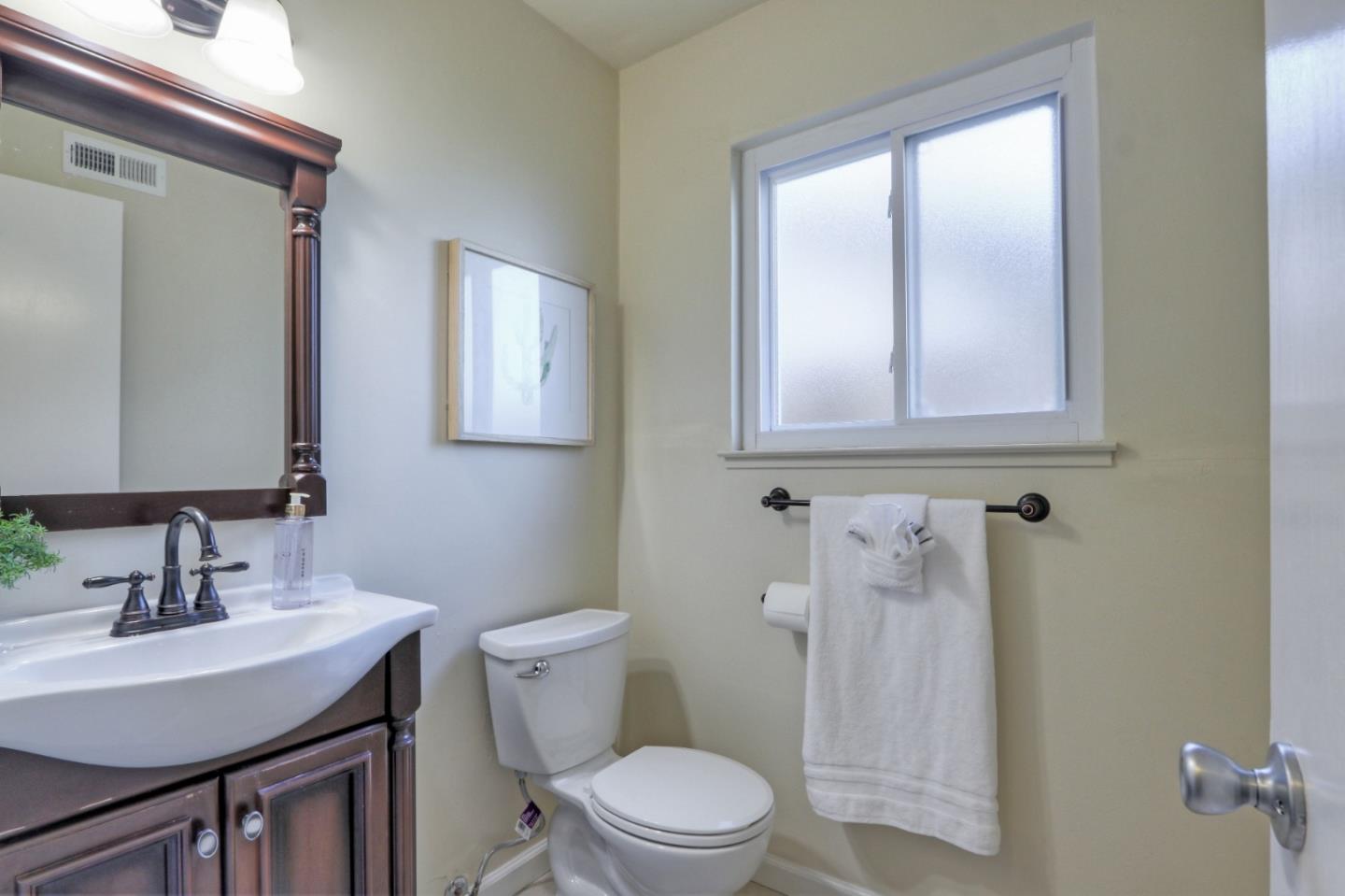 2250 Yosemite Drive Milpitas, CA 95035 - Photo 35 of 43 a bathroom with a toilet a sink a mirror and a window