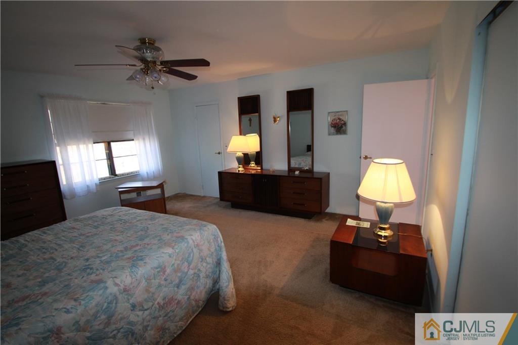 6605 Hana Road Edison, NJ 08817 - Photo 10 of 17 a bedroom with a bed and a chandelier
