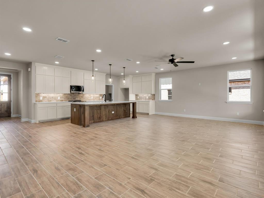 612 Jameson Springtown, TX 76082 - Photo 4 of 13 a large kitchen with stainless steel appliances kitchen island a large counter top and a wooden floors