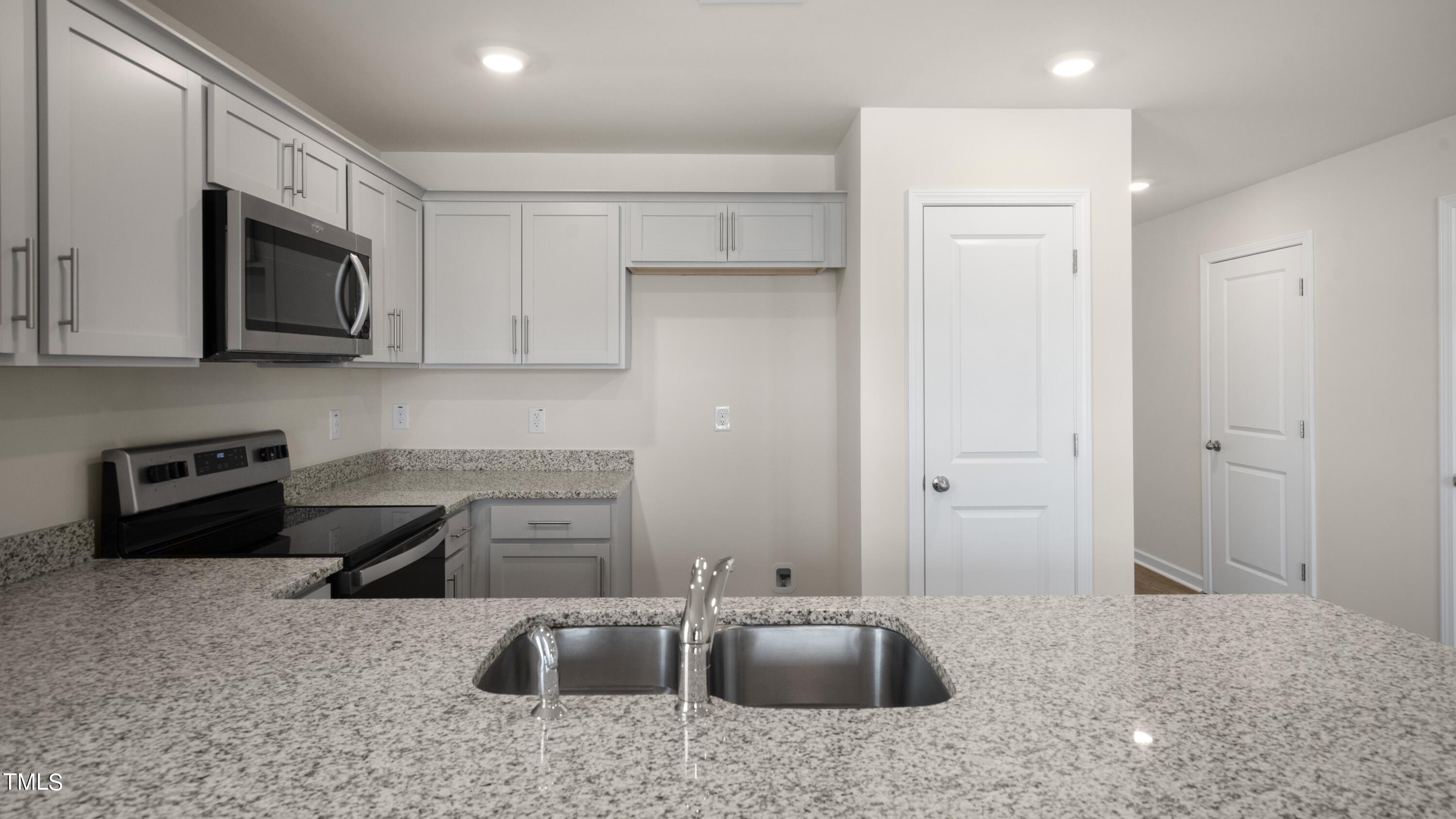 3202 Alibird Lane Carthage, NC 28327 - Photo 14 of 33 a kitchen with stainless steel appliances granite countertop a sink stove and microwave