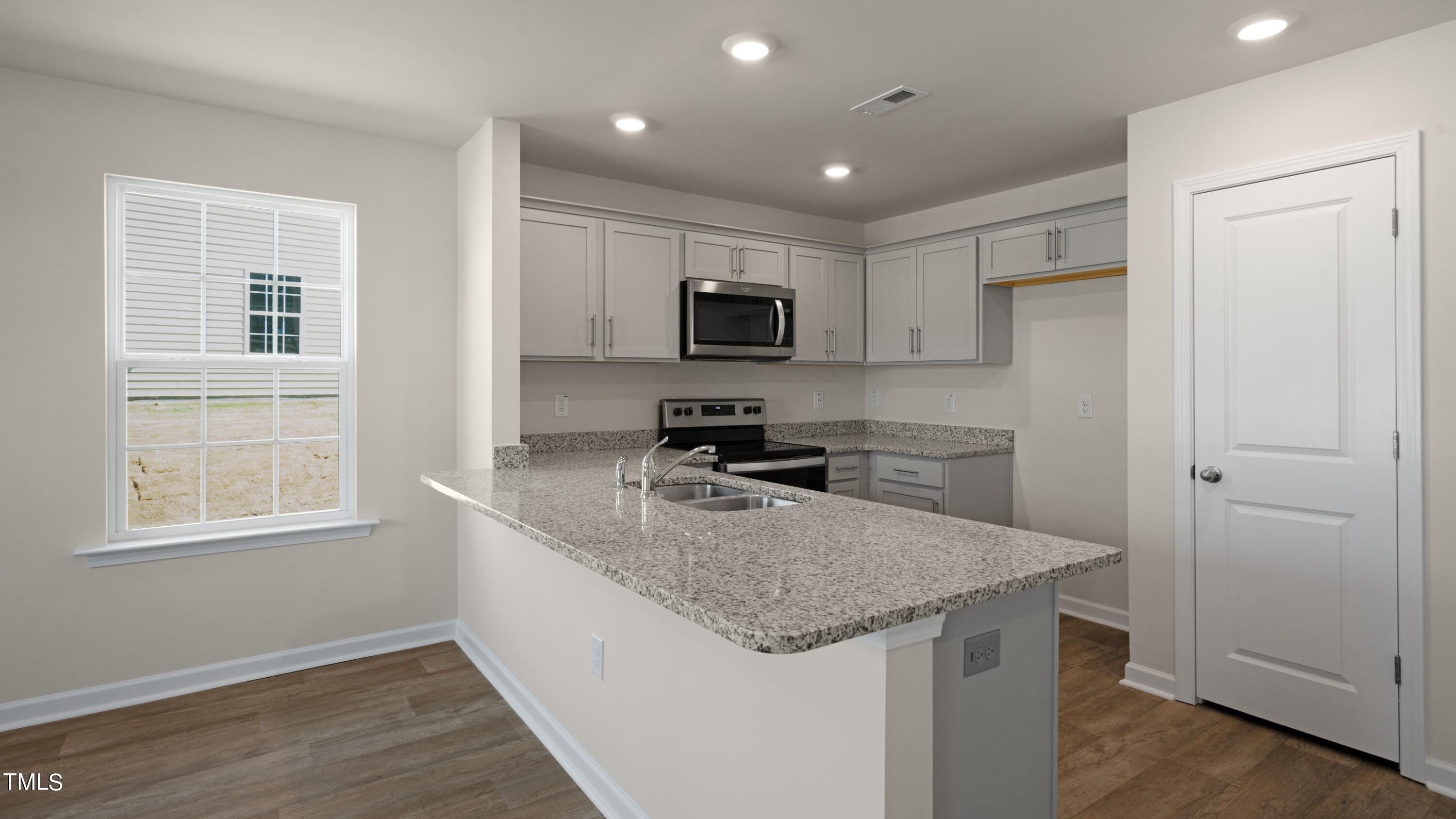 3202 Alibird Lane Carthage, NC 28327 - Photo 2 of 33 a kitchen with kitchen island granite countertop stainless steel appliances a sink stove and refrigerator